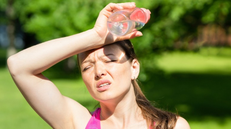 woman in the hot sun feeling dehydrated 