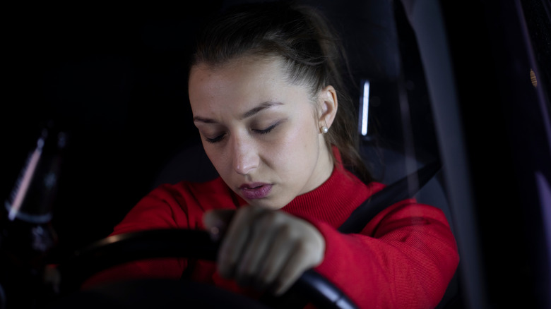 Woman falling asleep while driving car