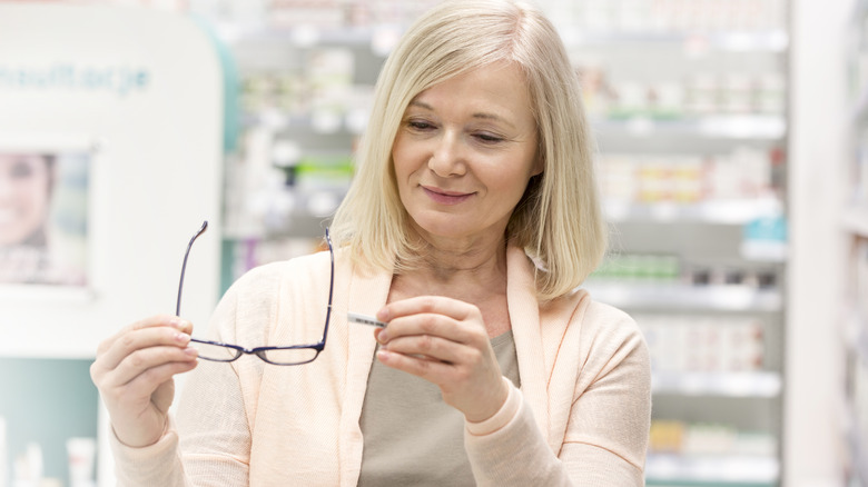 Woman holding reading glasses