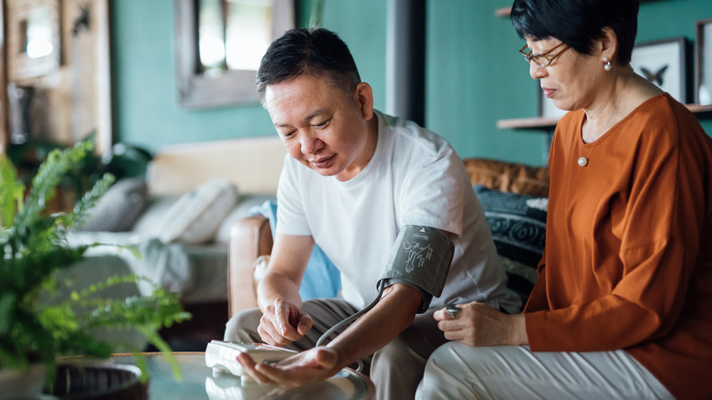 Elderly couple measuring blood pressure