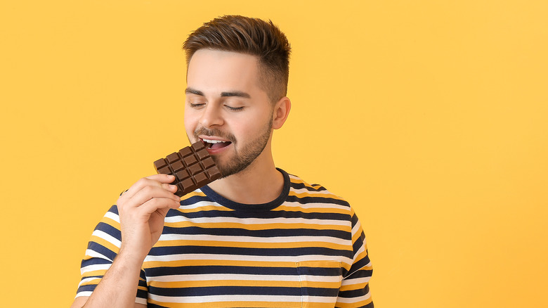 man eating chocolate bar