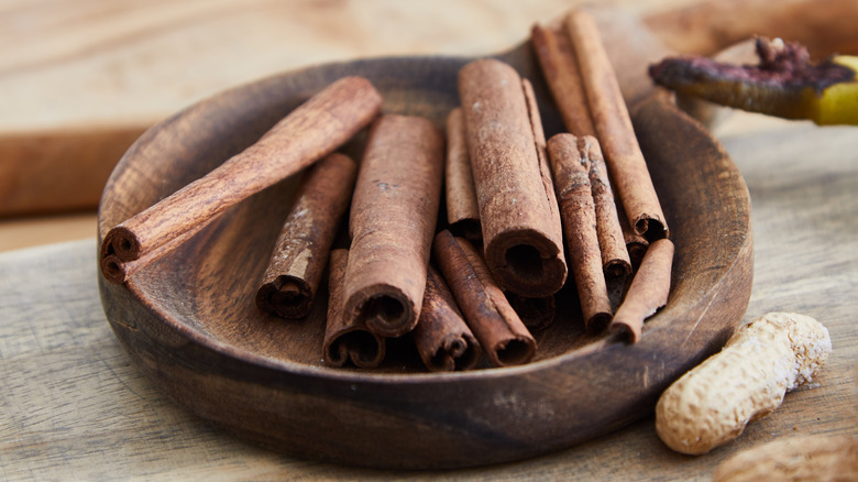 pieces of cinnamon bark on a wooden bowl