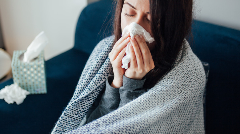 Woman with cold blowing nose