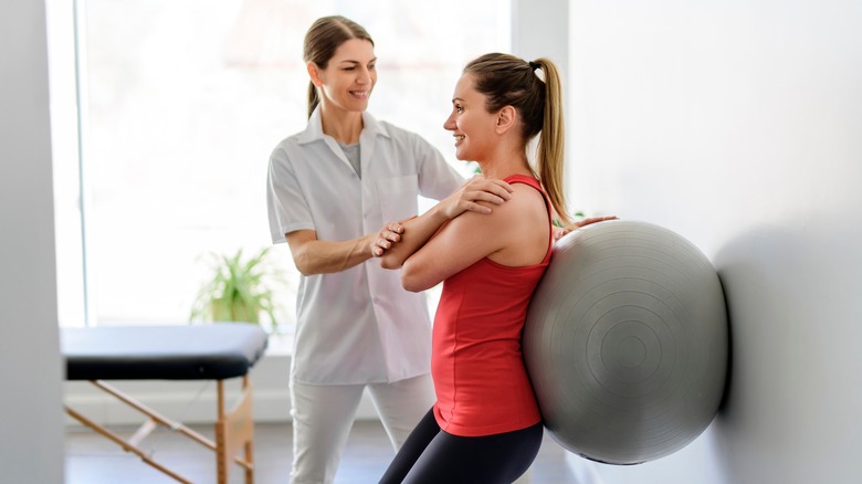 physiotherapist supervising exercise session