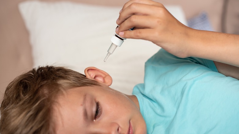 child receiving ear drops