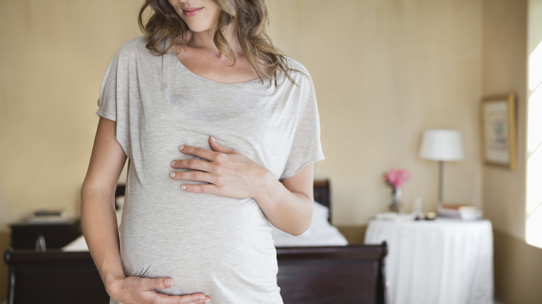 pregnant woman holding stomach