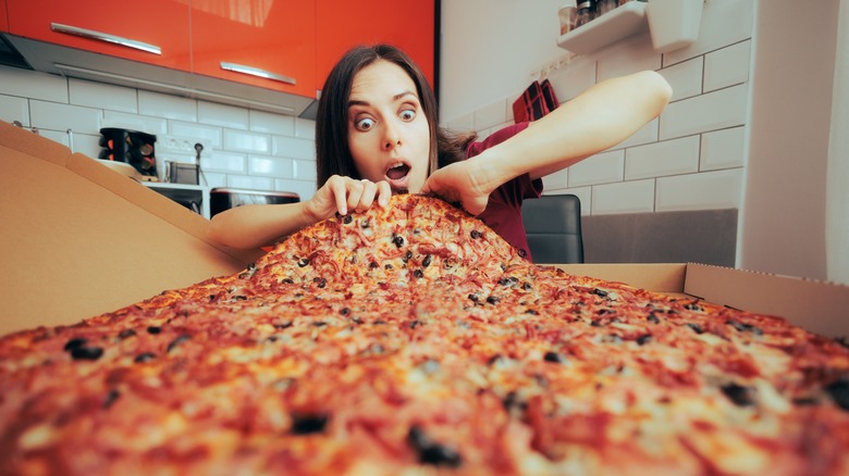 woman eating exceptionally large pizza