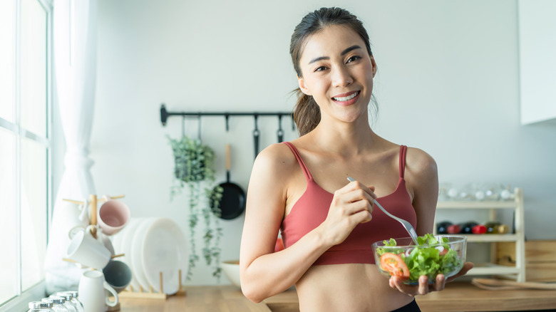 A fit woman eats a salad