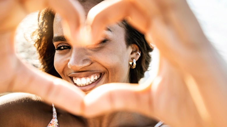 woman smiling through heart shape