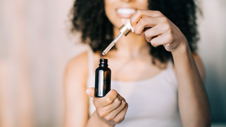 Woman holding essential oil bottle