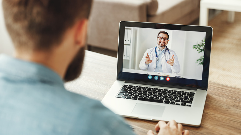 man talking to doctor on laptop