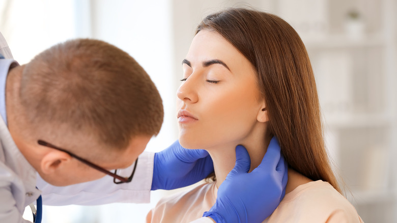 doctor checking woman's throat