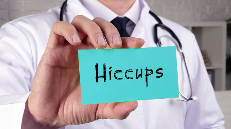 Doctor holding hiccups card