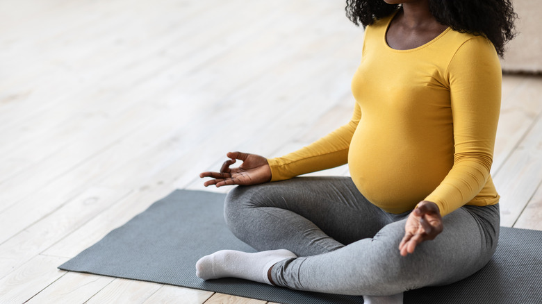 Pregnant woman meditating on mat