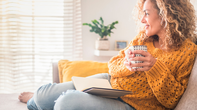 a woman enjoying reading and drinking tea