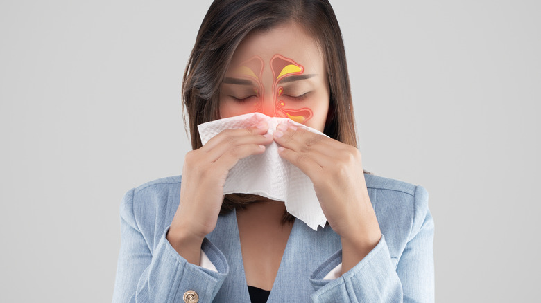 Woman blowing inflamed nose