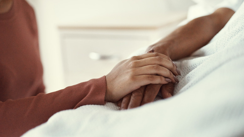 Holding hands in hospital bed