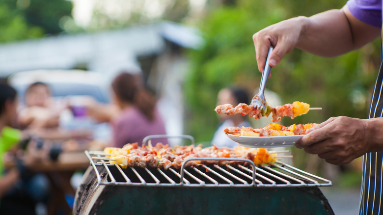 Man grabbing food on the grill