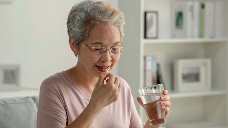 Woman taking pill with water