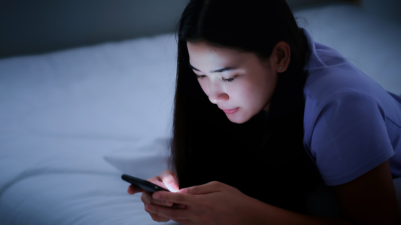 woman looking at her phone at night