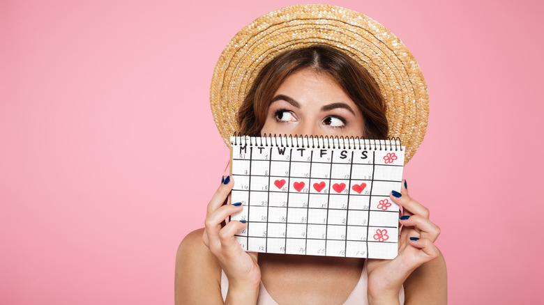 young woman in hat holding calendar