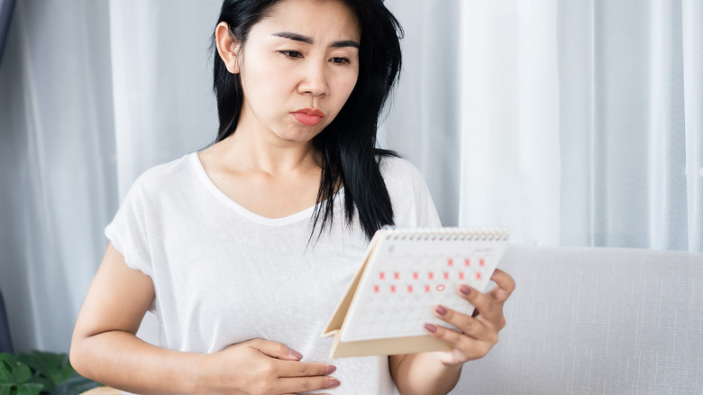 woman looking at menstruation calendar