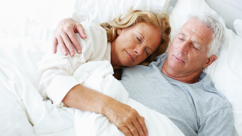 elderly couple sleeping in bed
