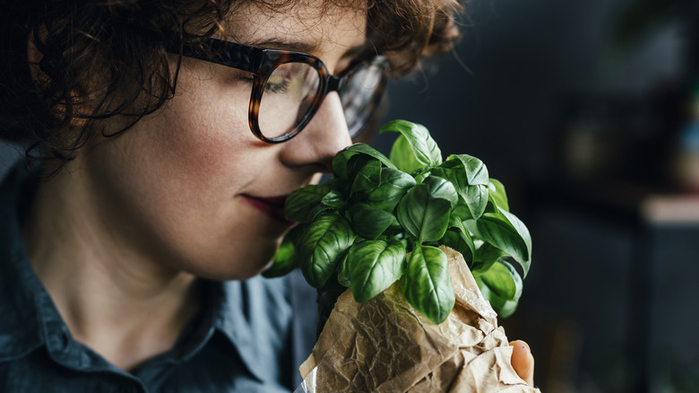 woman smelling fresh basil