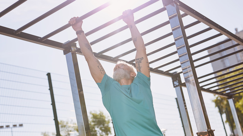 Man exercising on monkey bars