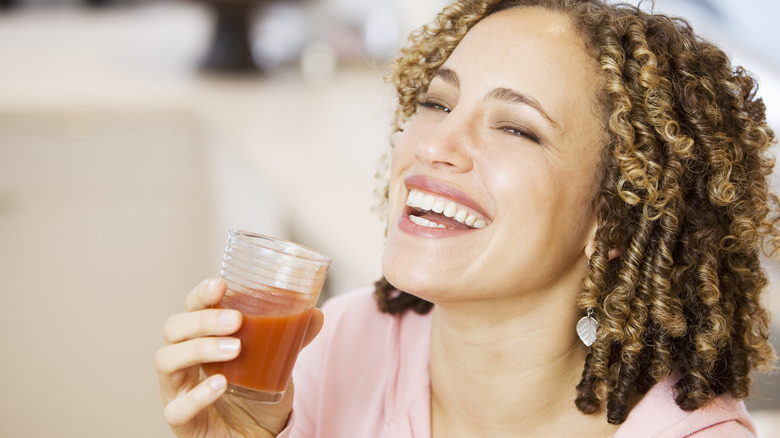 happy woman drinking tomato juice