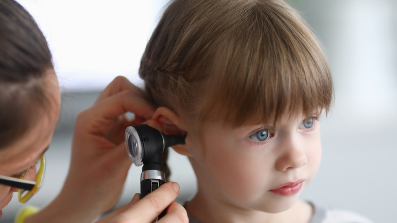 doctor examining child with ear infection