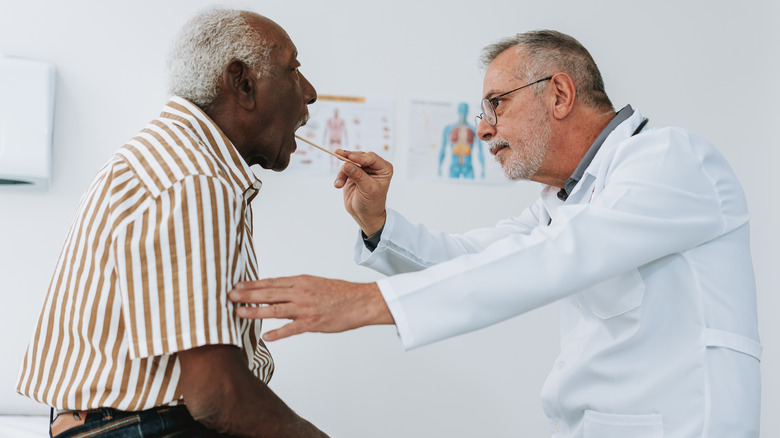 Doctor examining patient's throat