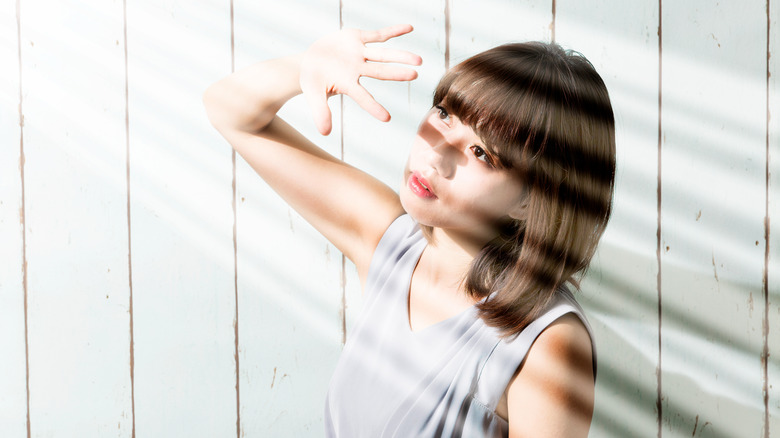 Woman trying to block the sun with her hand