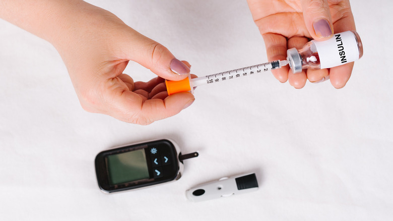 hand drawing out insulin with a syringe