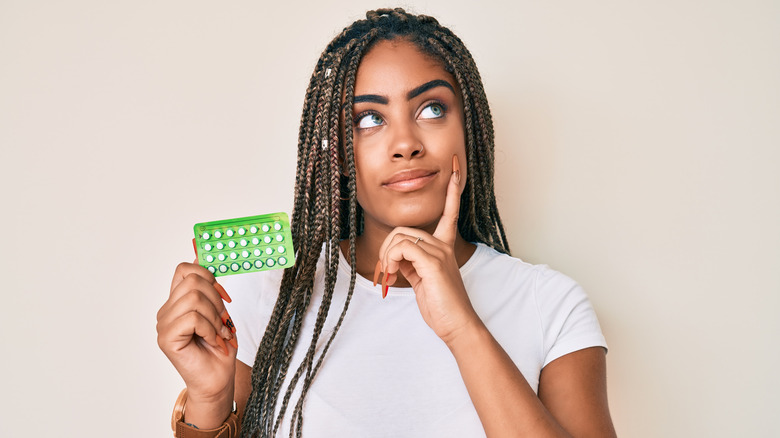 Woman holding birth control pills 