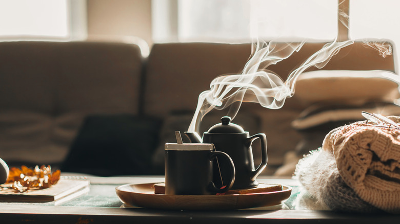 Steaming teapot and mug of tea