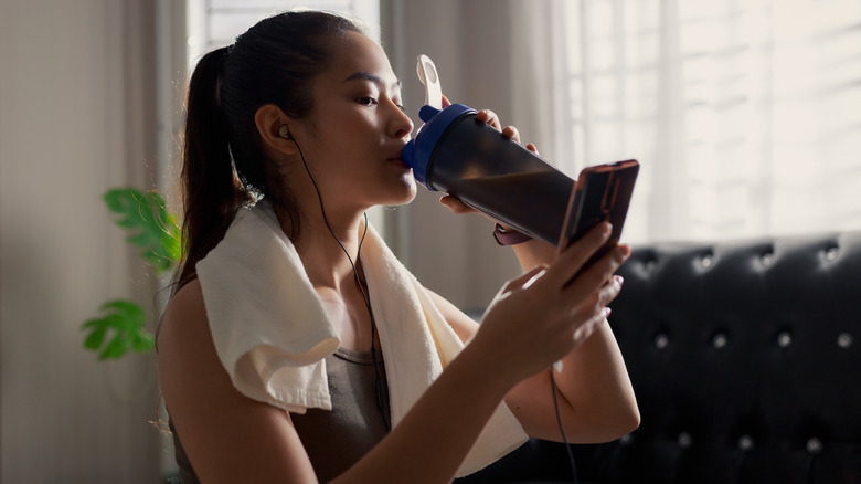 Fit woman drinking a protein shake