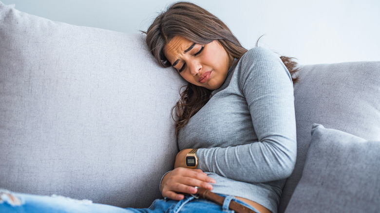 Grimacing woman holding her stomach