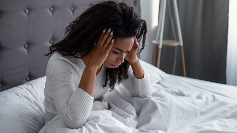 Woman in bed suffering from hangover