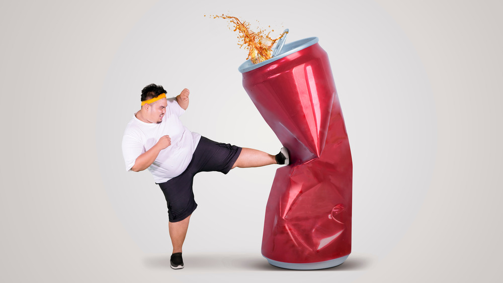 man kicking soda can