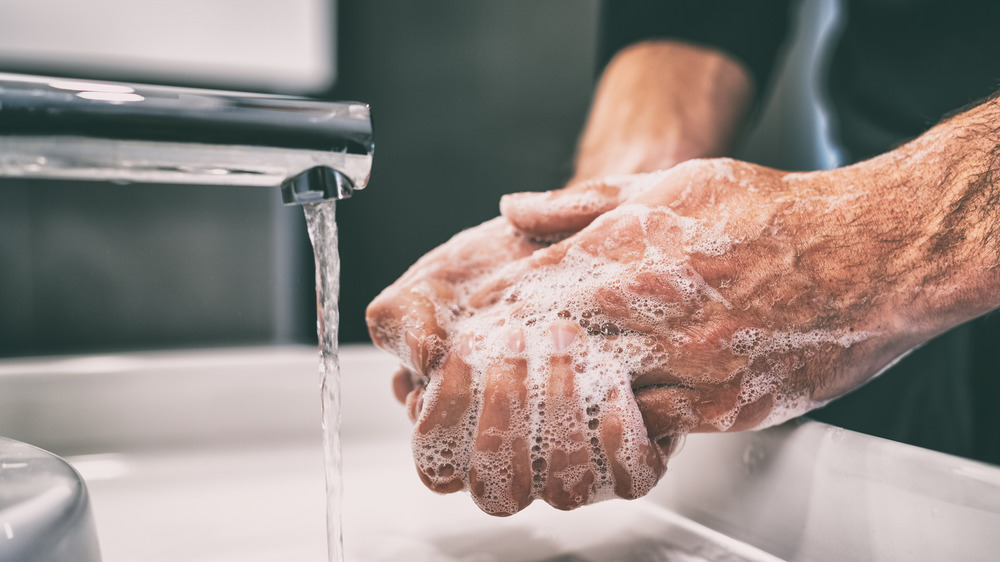 Man washing hands with warm, soapy water