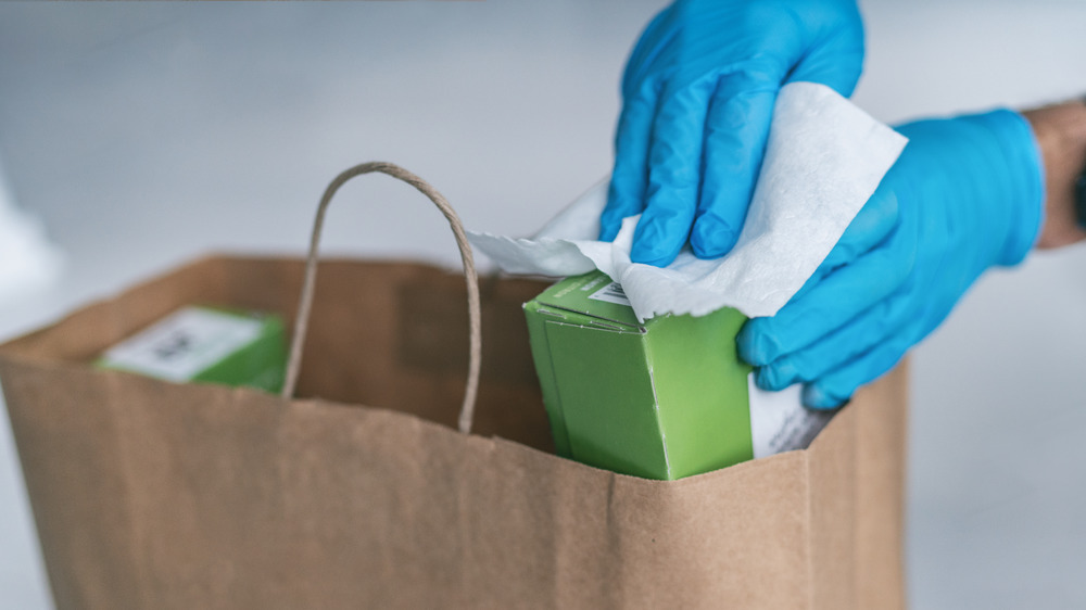 Person wearing gloves while wiping down food packages