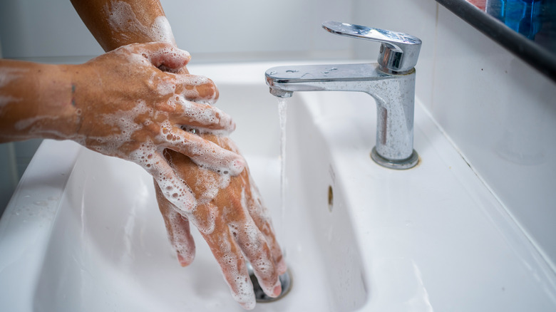 A man's hands washing in the sink