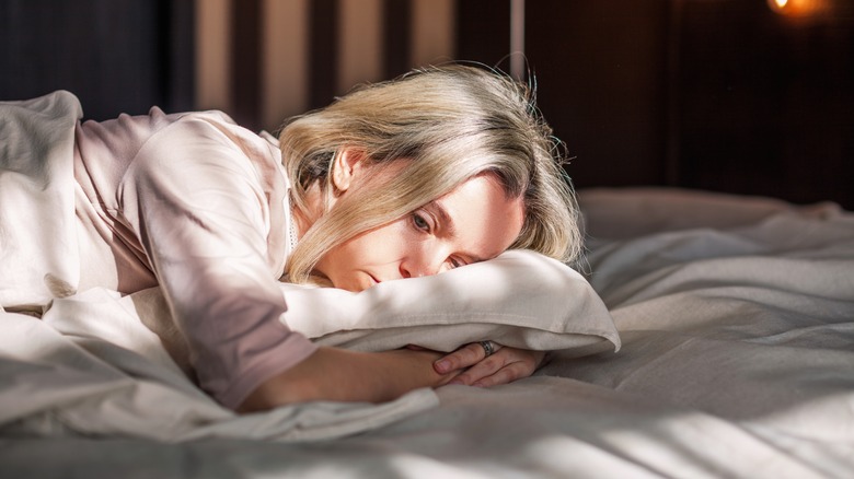 Woman lying in bed during day