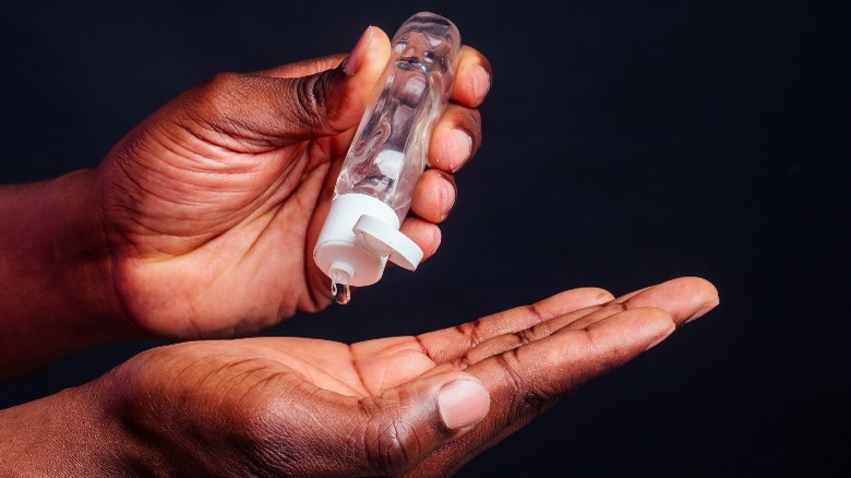 African American male using hand sanitizer