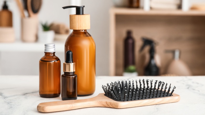 hair brush and hair oils on table