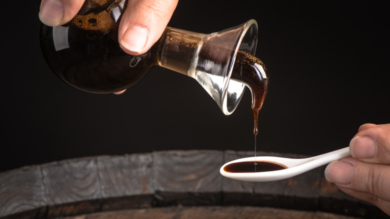 woman pouring balsamic vinegar into spoon