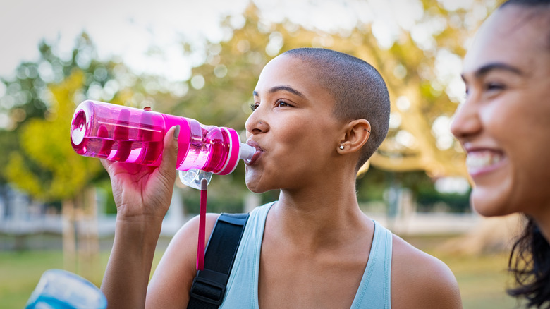 Young smiling women drinking water