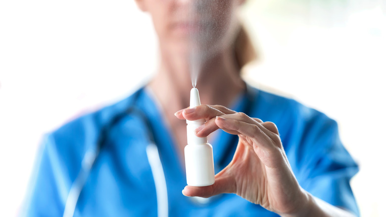 female nurse holding up nose spray 