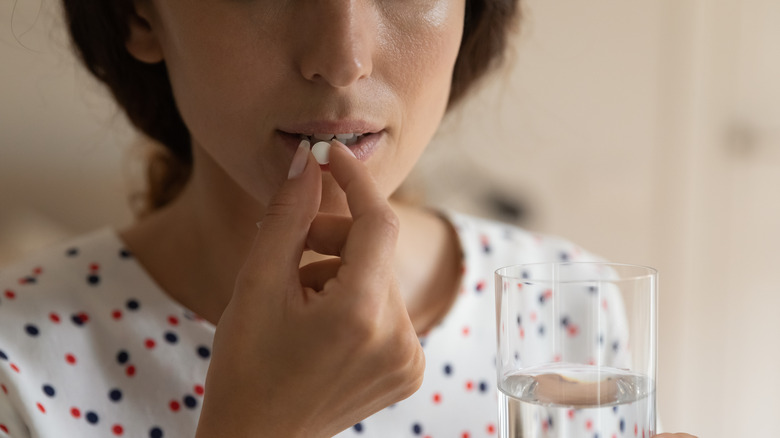 Woman taking pill with water